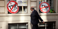 Ein Mann läuft an Schildern vorbei, die sich gegen TTIP und Ceta wenden