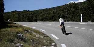 Ein Profiradfahrer fährt eine Straße entlang