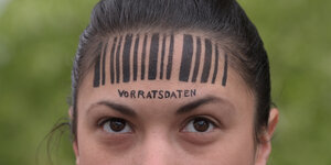Eine Frau hat einen Strichcode und den Schriftzug "Vorratsdaten" auf der Stirn