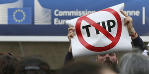 Ein Mann hält ein Anti-TTIP-Plakat hoch