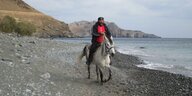 Ein Mann auf einem Pferd am Strand