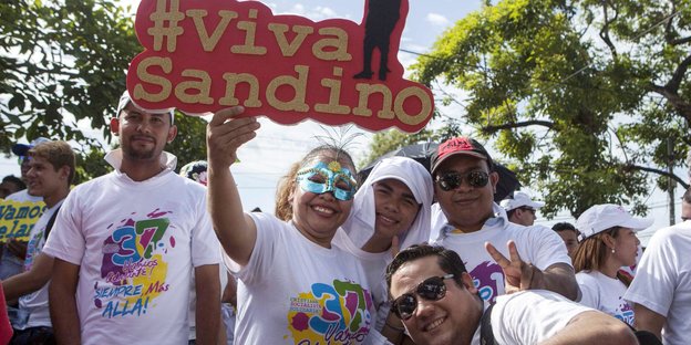 Fröhliche Menschen mit bunden Tshirts und einem Schuld #Viva Sandino