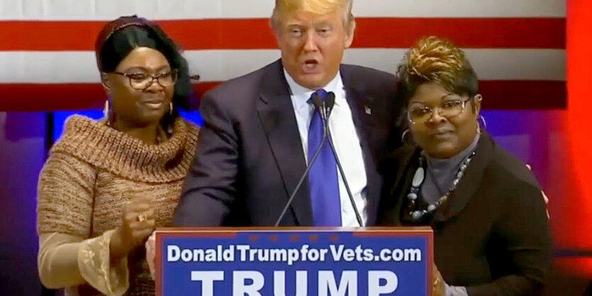 Donald Trump mit den Videobloggerinnen Diamond and Silk auf einem Podium