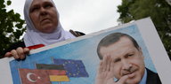 Eine Demonstrantin mit einem Plakat von Erdogan vor der Botschaft in Berlin.