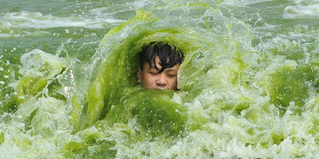 Ein Junge im Wirbel grüner Wellen