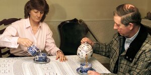 Prince Charles und eine Frau trinken Tee