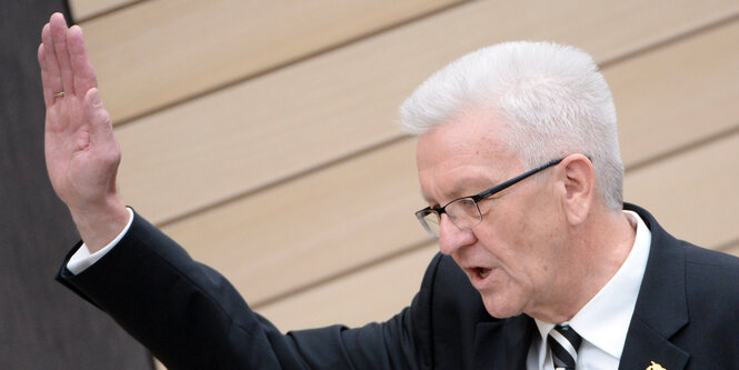 Winfried Kretschmann hebt die Hand zum Eid