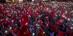 Menschenmenge mit vielen türkischen Flaggen am Abend