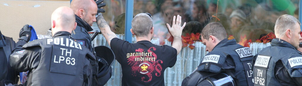 Ein Besucher wird vor Beginn eines Rechtsrock-Konzerts von der Polizei kontrolliert.