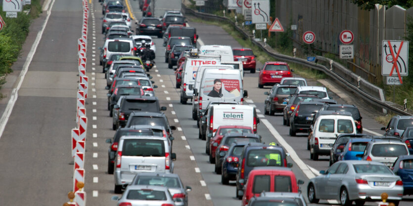 Auf einer dreispurigen Autobahn stehen Autos im Stau