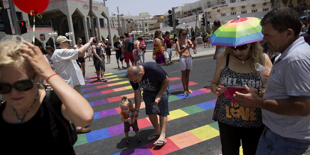 Menschen laufen bei der jährlichen Gay Pride in Tel Aviv über einen regenbogenfarbenen Zebrastreifen