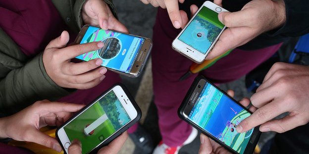 Vier Smartphones, auf denen Pokemon Go läuft