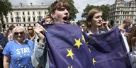 Junge Menschen auf einer Demonstration mit der EU-Fahne in den Händen