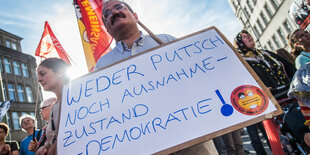 Ein mann hält ein Schild mit der Aufschrift: „Weder Putsch noch Ausnahmezustand – Demokratie!“