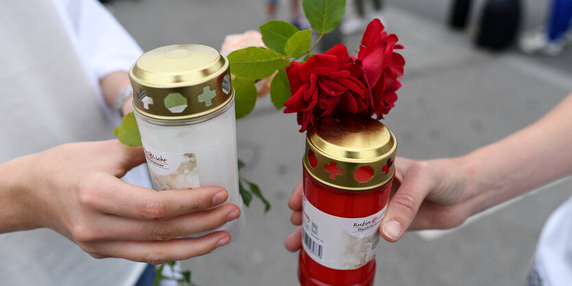 Hände mit Kerzen und Blumen