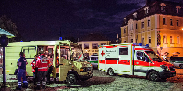 Rettungswagen und Sanitäter stehen auf einem großen Platz