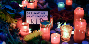 Blumen, Kerzen und ein Schild mit der Aufschrift "R.I.P., Das habt ihr nicht verdient"