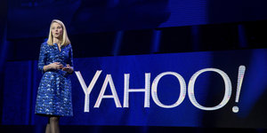Marissa Mayer vor einem großen Yahoo-Logo