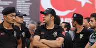 Türkische Polizisten stehen vor einer Flagge