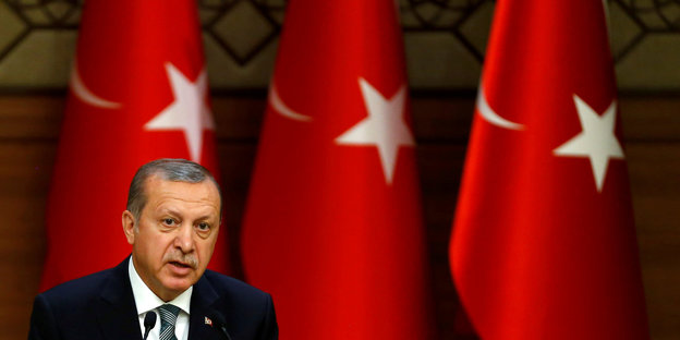 Ein Mann vor türkischen Flaggen. Es ist Recep Tayyip Erdogan