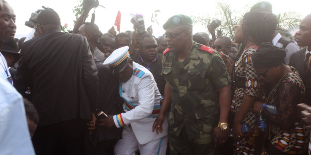 Zahlreiche Menschen aus Kongo, davon einige in Uniform, bei einer Beerdigung