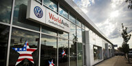 Die Front eines Autohauses mit VW-Logo und Amerikaflaggensterchen