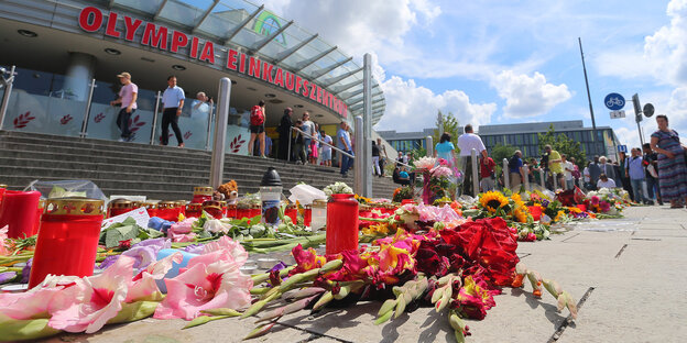 Blumen liegen auf dem Boden vor dem Olympia-Einkaufszentrum