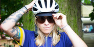 Eine Frau mit Fahrradkleidung und Sonnenbrille frontal im Porträt