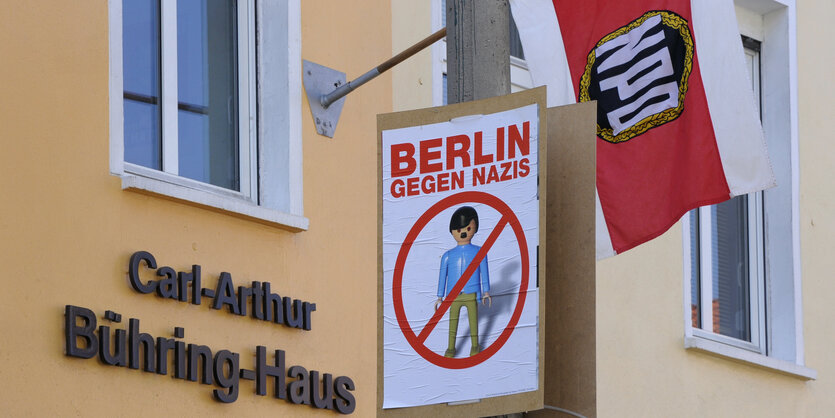 NPD-Flagge und Antinaziposter vor der NPD-Parteizentrale