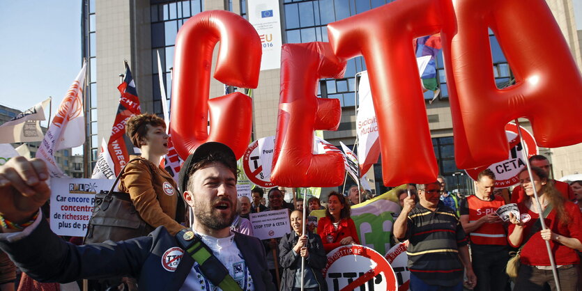 Menschen mit Plakaten und Luftballons demonstrieren gegen Ceta