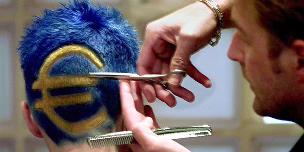Ein Frisör schneidet einem Kunden ein Euro-Zeichen in die Haare am Hinterkopf