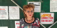 Die Sängerin Vivien Goldman steht vor einer plakatierten Wand