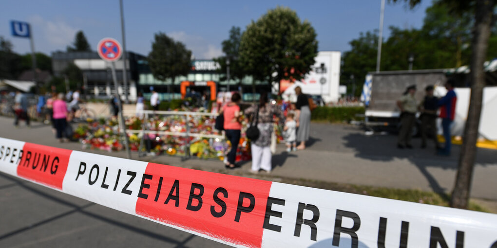 Blumen hinter einem Polizei-Absperrband