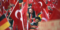 Viele Menschen mit Türkei-Flaggen, mittig ein Portrait von Erdogan