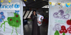 Eine Flüchtlingsfrau steht mit ihrem Baby in einem Zelt des UN-Kinderhilfswerkes Unicef an der Grenze zu Griechenland