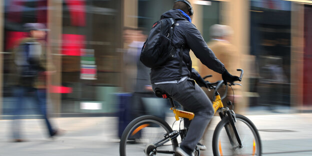 Fahrradfahrer fährt durch eine Fußgängerzone