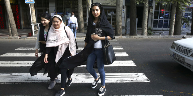 Jungen Frauen überqueren in Teheran die Straße