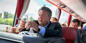 Sigmar Gabriel sitzt in einem Zug und benutzt sein Handy