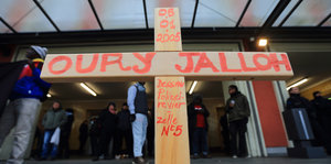 Ein Holzkreuz. Darauf steht: Oury Jalloh, 5.1.2005, Dessau Polizeirevier