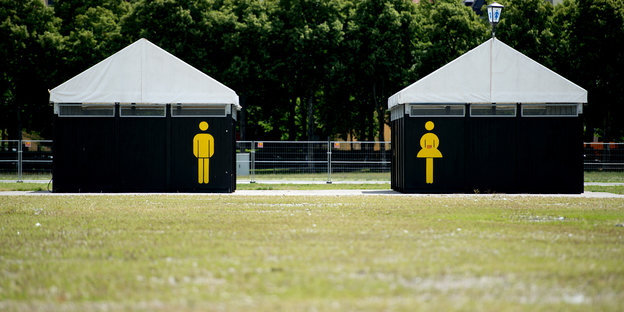 zwei Toilettenhäuschen mit geschlechterpiktogrammen
