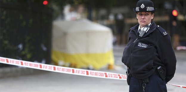 Eine Polizistin steht vor dem abgesperrten Tatort am Russell Square in London