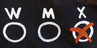 Drei weiße Checkboxen auf schwarzem Grund, „W“, „M“ und „X“