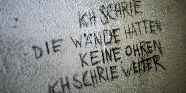 Eine halbverottete Wand, auf der steht: "Ich schrie die wände hatten keine ohren ich schrie weiter""