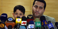 Schahram Amiri mit seinem Sohn bei seiner Rückkehr aus den USA bei einer Pressekonferenz.
