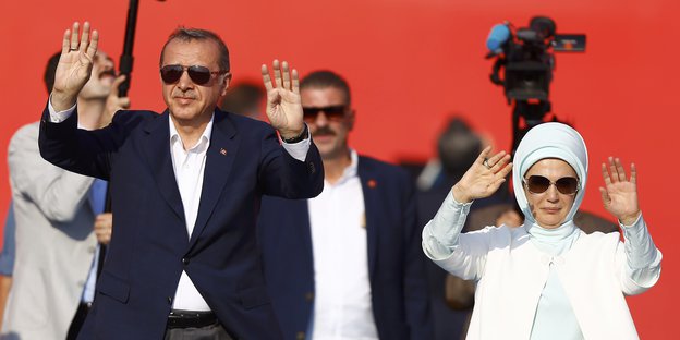 Tayyip Erdogan und seine Frau Emine Gulbaran halten die Hände hoch