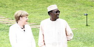 Angela Merkel und Idriss Déby auf einer grünen Rasenfläche