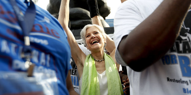 Strahlende, winkende Jill Stein inmitten einer Menschenmenge