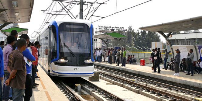 Menschen warten auf eintreffenden Zug