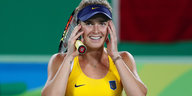 Die Tennisspielerin lächelt und kuckt leicht ungläubig
