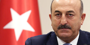 Mevlüt Cavusoglu vor einer Türkeifahne